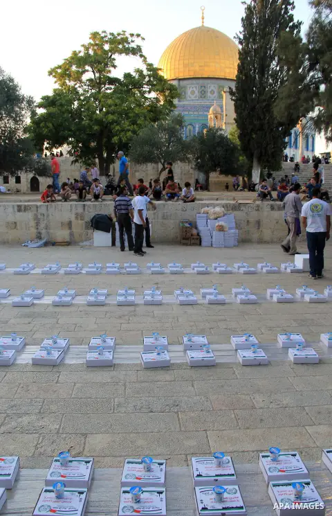 Palestinian muslims prepare to break their fast during the holy fasting month of Ramadan in front of the Dome of the Rock mosque at the al-Aqsa mosque compound, in Jerusalem's old city on June 22, 2016. Ramadan is sacred...