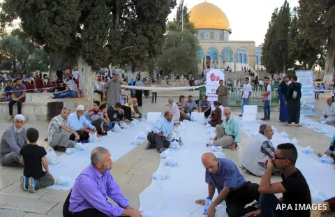 Palestinian muslims prepare to break their fast during the holy fasting month of Ramadan in front of the Dome of the Rock mosque at the al-Aqsa mosque compound, in Jerusalem's old city on June 22, 2016. Ramadan is sacred...