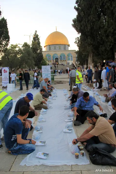 Palestinian muslims prepare to break their fast during the holy fasting month of Ramadan in front of the Dome of the Rock mosque at the al-Aqsa mosque compound, in Jerusalem's old city on June 22, 2016. Ramadan is sacred...