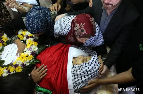 The mother of Palestinian boy Mahmoud Badran, 15, who was killed by Israeli troops on Tuesday, kisses his body during his funeral in the village of Beit Ore-Tahta near the West Bank city of Ramallah June 23, 2016. Photo...