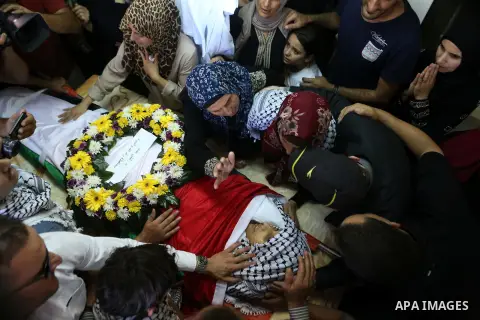 The mother of Palestinian boy Mahmoud Badran, 15, who was killed by Israeli troops on Tuesday, kisses his body during his funeral in the village of Beit Ore-Tahta near the West Bank city of Ramallah June 23, 2016. Photo...