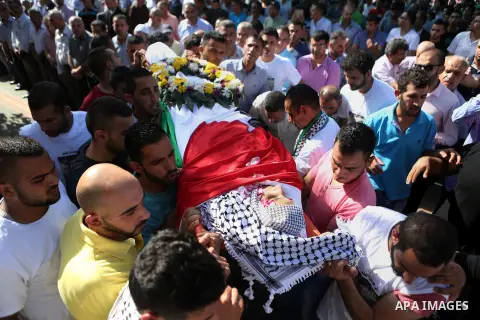 Mourners carry the body of Palestinian boy Mahmoud Badran, 15, who was killed by Israeli troops on Tuesday, during his funeral in the village of Beit Ore-Tahta near the West Bank city of Ramallah June 23, 2016. Photo by...