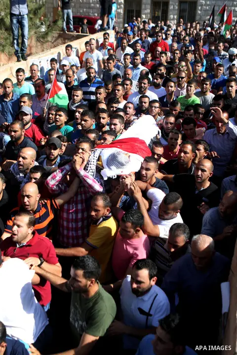 Mourners carry the body of Palestinian boy Mahmoud Badran, 15, who was killed by Israeli troops on Tuesday, during his funeral in the village of Beit Ore-Tahta near the West Bank city of Ramallah June 23, 2016. Photo by...