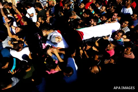Mourners carry the body of Palestinian boy Mahmoud Badran, 15, who was killed by Israeli troops on Tuesday, during his funeral in the village of Beit Ore-Tahta near the West Bank city of Ramallah June 23, 2016. Photo by...