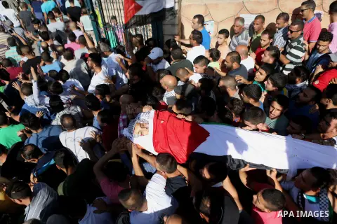 Mourners carry the body of Palestinian boy Mahmoud Badran, 15, who was killed by Israeli troops on Tuesday, during his funeral in the village of Beit Ore-Tahta near the West Bank city of Ramallah June 23, 2016. Photo by...