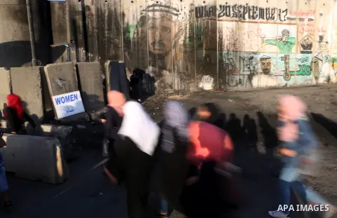 Palestinians walk past Qalandia checkpoint between the West Bank city of Ramallah and Jerusalem on June 24, 2016, as they head to Jerusalem's Al-Aqsa mosque for the third Friday prayer of the holy Muslim fasting month of...