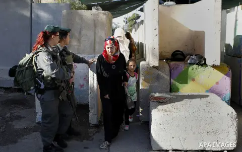 Palestinians walk through an Israeli checkpoint as they make their way to attend the third Friday prayer of the holy fasting month of Ramadan in Jerusalem's al-Aqsa mosque, in the West bank city of Bethlehem June 24, 201...