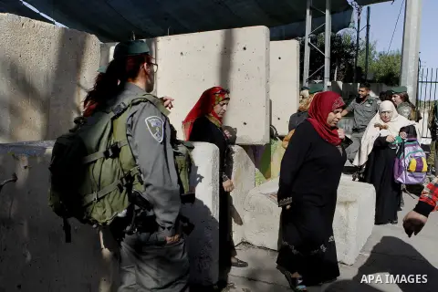 Palestinians walk through an Israeli checkpoint as they make their way to attend the third Friday prayer of the holy fasting month of Ramadan in Jerusalem's al-Aqsa mosque, in the West bank city of Bethlehem June 24, 201...