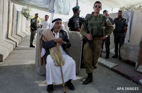 Palestinians walk through an Israeli checkpoint as they make their way to attend the third Friday prayer of the holy fasting month of Ramadan in Jerusalem's al-Aqsa mosque, in the West bank city of Bethlehem June 24, 201...