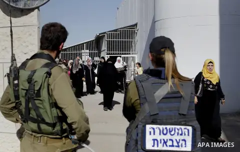 Palestinians walk through an Israeli checkpoint as they make their way to attend the third Friday prayer of the holy fasting month of Ramadan in Jerusalem's al-Aqsa mosque, in the West bank city of Bethlehem June 24, 201...