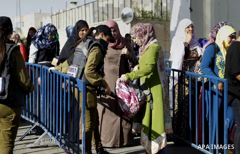 Palestinians walk through an Israeli checkpoint as they make their way to attend the third Friday prayer of the holy fasting month of Ramadan in Jerusalem's al-Aqsa mosque, in the West bank city of Bethlehem June 24, 201...