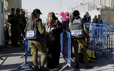 Palestinians walk through an Israeli checkpoint as they make their way to attend the third Friday prayer of the holy fasting month of Ramadan in Jerusalem's al-Aqsa mosque, in the West bank city of Bethlehem June 24, 201...