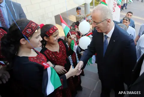 Palestinian Prime Minister Rami Hamdallah takes part during take breakfast for orphans on holy fasting month of Ramadan, at An-Najah national University, in the West Bank City of Nablus, on June 24, 2016. Photo by Prime...