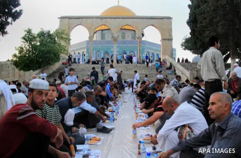 Palestinian muslims prepare to break their fast during the holy fasting month of Ramadan in front of the Dome of the Rock mosque at the al-Aqsa mosque compound, in Jerusalem's old city on June 25, 2016. Ramadan is sacred...
