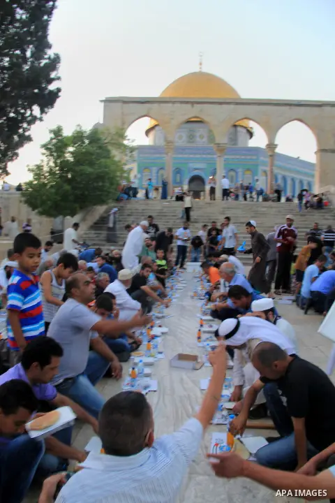 Palestinian muslims prepare to break their fast during the holy fasting month of Ramadan in front of the Dome of the Rock mosque at the al-Aqsa mosque compound, in Jerusalem's old city on June 25, 2016. Ramadan is sacred...
