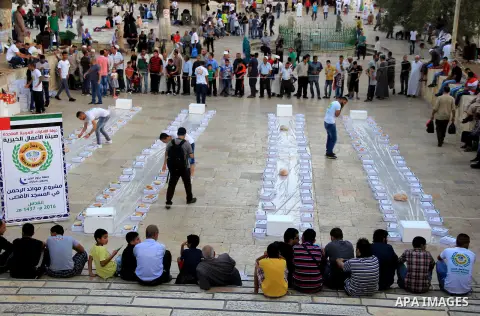 Palestinian muslims prepare to break their fast during the holy fasting month of Ramadan in front of the Dome of the Rock mosque at the al-Aqsa mosque compound, in Jerusalem's old city on June 25, 2016. Ramadan is sacred...