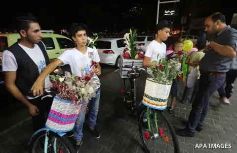 Palestinian youths wander on colorful bicycles and sell flowers at street in Gaza city, on June 26, 2016. Unemployment in the Palestinian enclave of Gaza has risen dramatically to reach around 45 percent, one of the high...