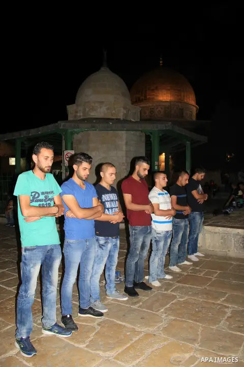Palestinian Muslim worshippers perform "Taraweeh", nightly prayer of the month of Ramadan, in front of the Dome of the Rock mosque, in Jerusalem's old city on June 26, 2016. Ramadan is sacred to Muslims because it is dur...