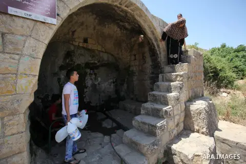 A Palestinian boy carries a jerrican filled with spring water on June 27, 2016 in Salfit, north of Ramallah, where some of the West Bank village's inhabitants have been without water for days. Tens of thousands of Palest...