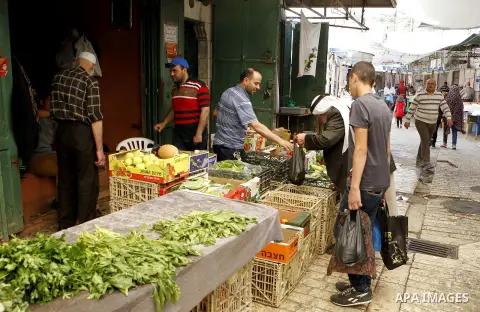 Palestinians shop at a market during the holy month of Ramadan in the West Bank city of Hebron, on June 28, 2016. Photo by Wisam Hashlamoun