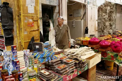 Palestinians shop at a market during the holy month of Ramadan in the West Bank city of Hebron, on June 28, 2016. Photo by Wisam Hashlamoun