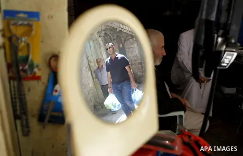Palestinians shop at a market during the holy month of Ramadan in the West Bank city of Hebron, on June 28, 2016. Photo by Wisam Hashlamoun