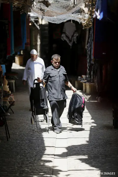Palestinians shop at a market during the holy month of Ramadan in the West Bank city of Hebron, on June 28, 2016. Photo by Wisam Hashlamoun