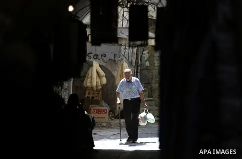 Palestinians shop at a market during the holy month of Ramadan in the West Bank city of Hebron, on June 28, 2016. Photo by Wisam Hashlamoun