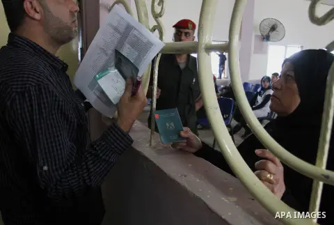 A woman looks through a window as she waits for a travel permit to cross into Egypt through the Rafah border crossing after it was opened by Egyptian authorities for five days, in the southern Gaza Strip June 29, 2016. P...