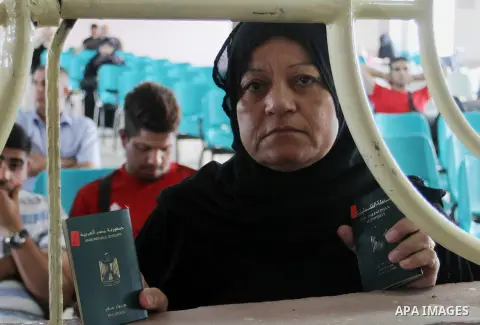 A woman looks through a window as she waits for a travel permit to cross into Egypt through the Rafah border crossing after it was opened by Egyptian authorities for five days, in the southern Gaza Strip June 29, 2016. P...