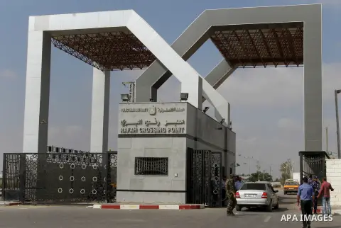Security stand guard as Palestinians residing in the Gaza Strip wait for a travel permit to cross into Egypt through the Rafah border crossing after it was opened by Egyptian authorities for five days, in the southern Ga...