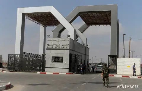 Security stand guard as Palestinians residing in the Gaza Strip wait for a travel permit to cross into Egypt through the Rafah border crossing after it was opened by Egyptian authorities for five days, in the southern Ga...