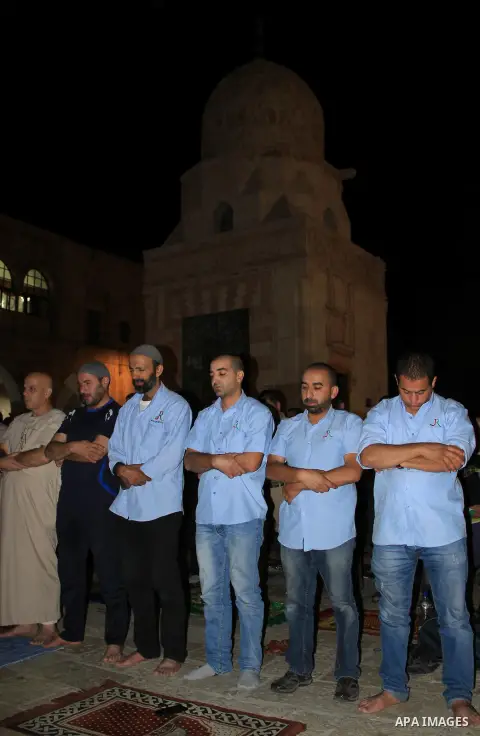 Palestinian Muslim worshippers perform "Taraweeh", nightly prayer of the month of Ramadan, in front of the Dome of the Rock mosque, in Jerusalem's old city on June 29, 2016. Ramadan is sacred to Muslims because it is dur...