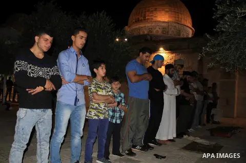 Palestinian Muslim worshippers perform "Taraweeh", nightly prayer of the month of Ramadan, in front of the Dome of the Rock mosque, in Jerusalem's old city on June 29, 2016. Ramadan is sacred to Muslims because it is dur...