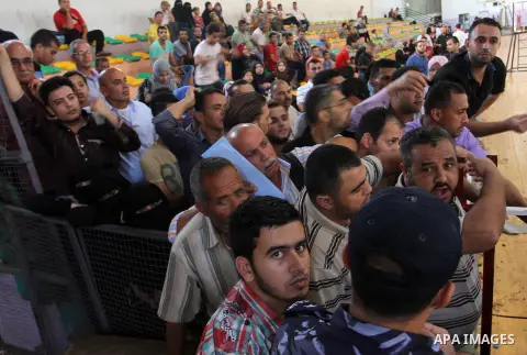Palestinians wait for a travel permit to cross into Egypt through the Rafah border crossing after it was opened by Egyptian authorities for five days, in the southern Gaza Strip June 30, 2016. Photo by Abed Rahim Khatib