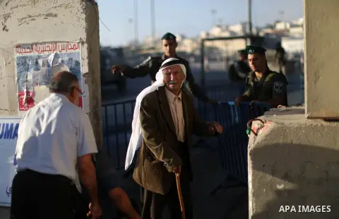 Palestinians wait to cross through Israeli Qalandia checkpoint as they make their way to attend the last Friday prayer of the holy fasting month of Ramadan in Jerusalem's al-Aqsa mosque, near the West Bank city of Ramall...