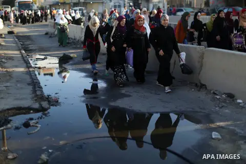 Palestinians wait to cross through Israeli Qalandia checkpoint as they make their way to attend the last Friday prayer of the holy fasting month of Ramadan in Jerusalem's al-Aqsa mosque, near the West Bank city of Ramall...