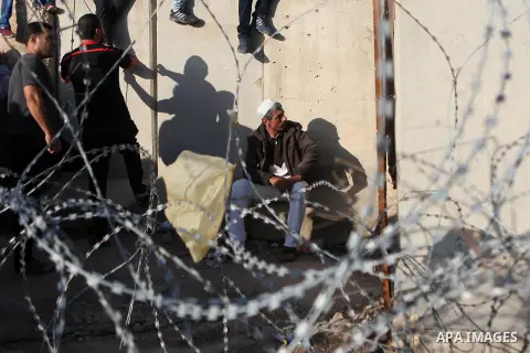 Palestinians wait to cross through Israeli Qalandia checkpoint as they make their way to attend the last Friday prayer of the holy fasting month of Ramadan in Jerusalem's al-Aqsa mosque, near the West Bank city of Ramall...