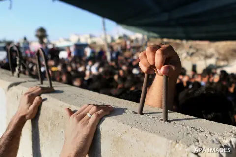 Palestinians wait to cross through Israeli Qalandia checkpoint as they make their way to attend the last Friday prayer of the holy fasting month of Ramadan in Jerusalem's al-Aqsa mosque, near the West Bank city of Ramall...