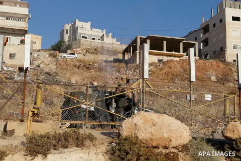 Palestinian men cross through a gap in the barbed-wire gate part of the controversial Israeli separation fence between the West Bank town of Bethlehem and Jerusalem, in an attempt to reach the Al-Aqsa Mosque compound in...