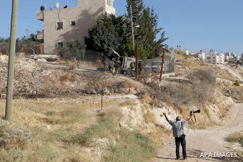 A Palestinian photographer reacts as Israeli border police fire teargas canisters near a barbed-wire gate part of the controversial Israeli separation fence between the West Bank town of Bethlehem and Jerusalem, after an...