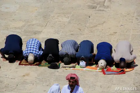 Palestinian men pray outside the Dome of the Rock in Jerusalem's Al-Aqsa mosque compound during the last Friday prayers of the holy Muslim fasting month of Ramadan on July 1, 2016. Photo by Mahfouz Abu Turk