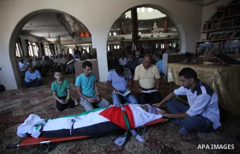 Mourners pray on the body of Palestinian Tayseer Habash, who died from tear gas fired by Israeli security forces during clashes, during his funeral on July 2, 2016 in the West Bank city of Nablus. Habash, 63, died on Jul...