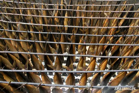 Mackerels are being smoked by Palestinians before selling them at a market ahead of the Eid al-Fitr holiday on July 2, 2016 in Khan Yunis, in the southern Gaza Strip. Eid al-Fitr marks the end of Muslim's holy fasting mo...
