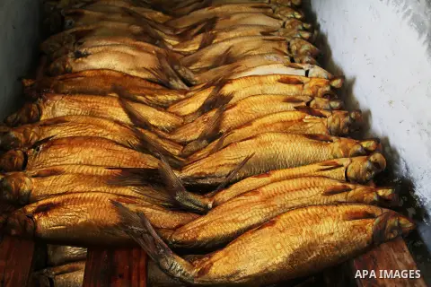 Mackerels are being smoked by Palestinians before selling them at a market ahead of the Eid al-Fitr holiday on July 2, 2016 in Khan Yunis, in the southern Gaza Strip. Eid al-Fitr marks the end of Muslim's holy fasting mo...