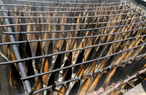Mackerels are being smoked by Palestinians before selling them at a market ahead of the Eid al-Fitr holiday on July 2, 2016 in Khan Yunis, in the southern Gaza Strip. Eid al-Fitr marks the end of Muslim's holy fasting mo...