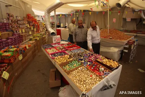 Palestinians shop at a market ahead of the Eid al-Fitr holiday, in the West Bank city of Nablus, on July 3, 2016. Eid al-Fitr marks the end of Muslim's holy fasting month of Ramadan when faithfuls abstain from eating, dr...