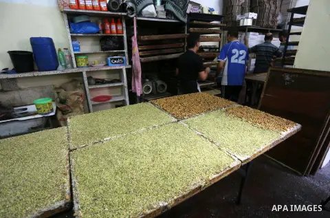 Palestinians prepare sweet known in Arabic as "Halkoum" ahead of the Eid al-Fitr holiday, in Gaza city, on July 3, 2016. Eid al-Fitr marks the end of Muslim's holy fasting month of Ramadan when faithfuls abstain from eat...