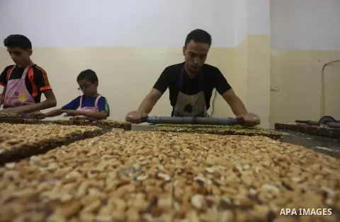 Palestinians prepare sweet known in Arabic as "Halkoum" ahead of the Eid al-Fitr holiday, in Gaza city, on July 3, 2016. Eid al-Fitr marks the end of Muslim's holy fasting month of Ramadan when faithfuls abstain from eat...