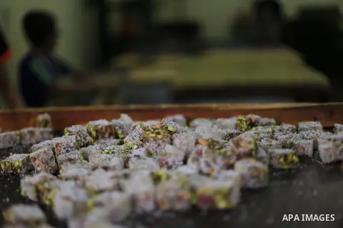 Palestinians prepare sweet known in Arabic as "Halkoum" ahead of the Eid al-Fitr holiday, in Gaza city, on July 3, 2016. Eid al-Fitr marks the end of Muslim's holy fasting month of Ramadan when faithfuls abstain from eat...